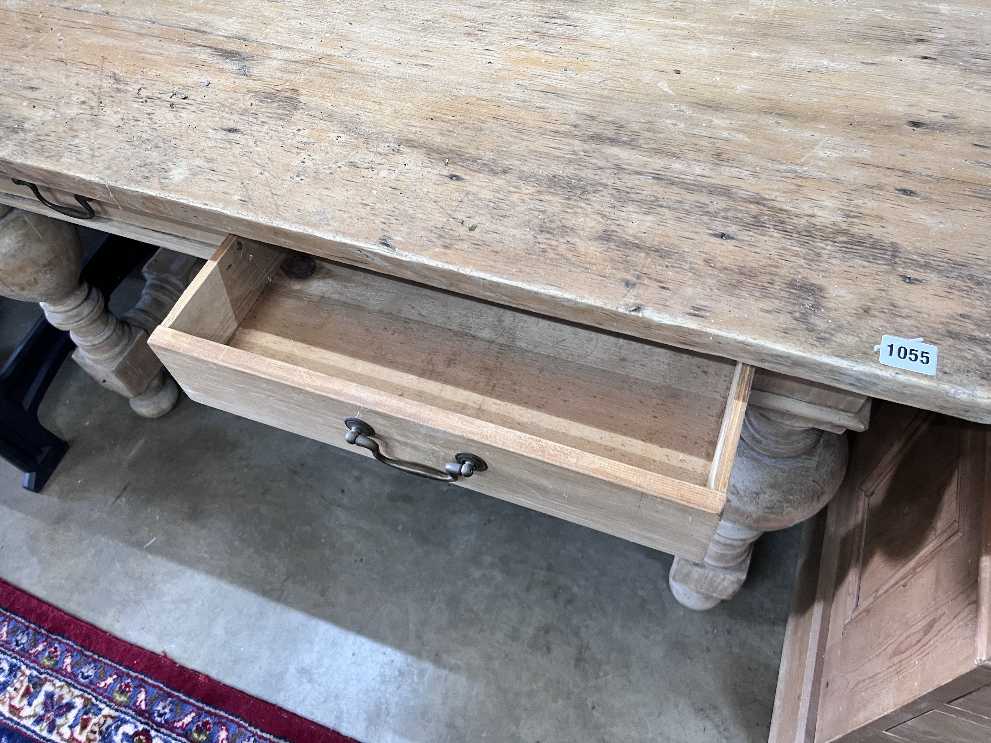 A Flemish style pine two drawer table, on bulbous end supports, width 122cm, depth 61cm, height 76cm